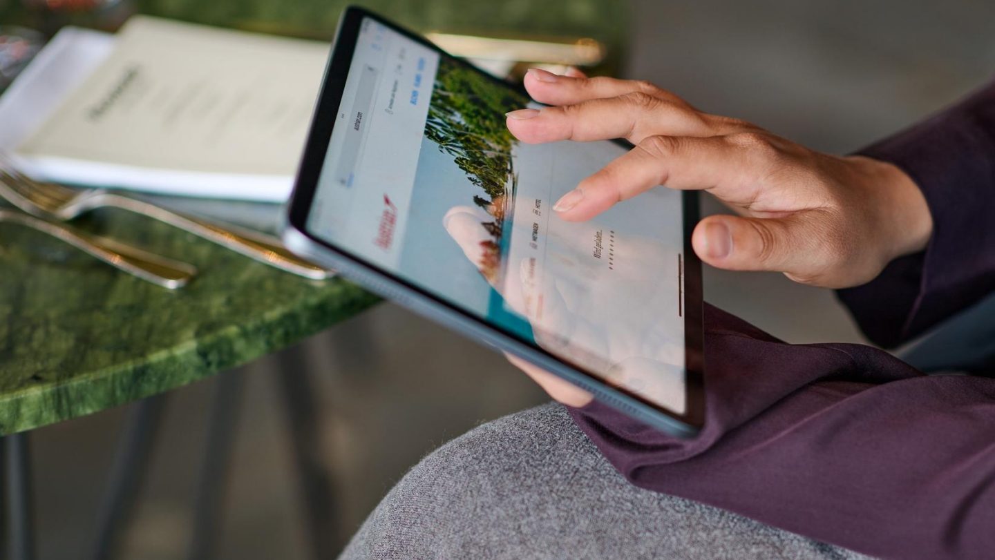 Close-up of a hand using a stylus on a digital tablet screen.
