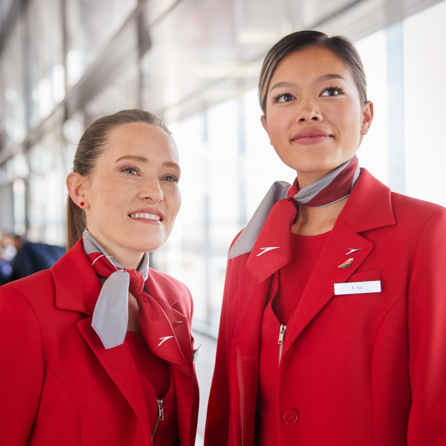 Two Austrian Airlines flight attendants smiling.