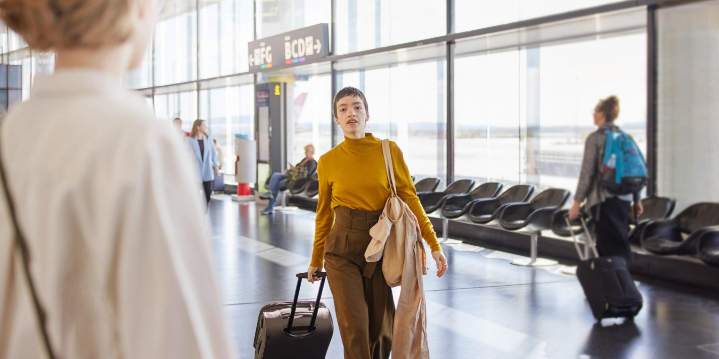 Woman pulling luggage at an airport.