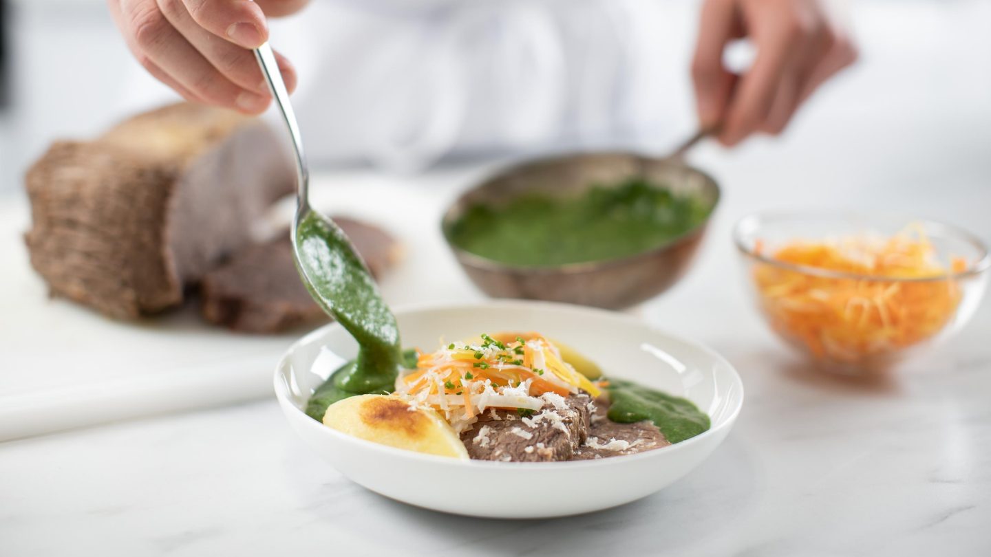 A person is mixing food in a bowl with a spoon.