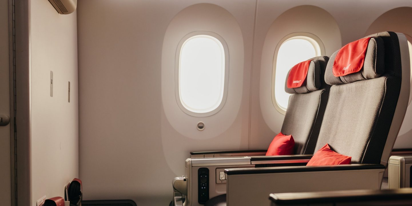 Premium Economy Class passenger operates the screen at his seat