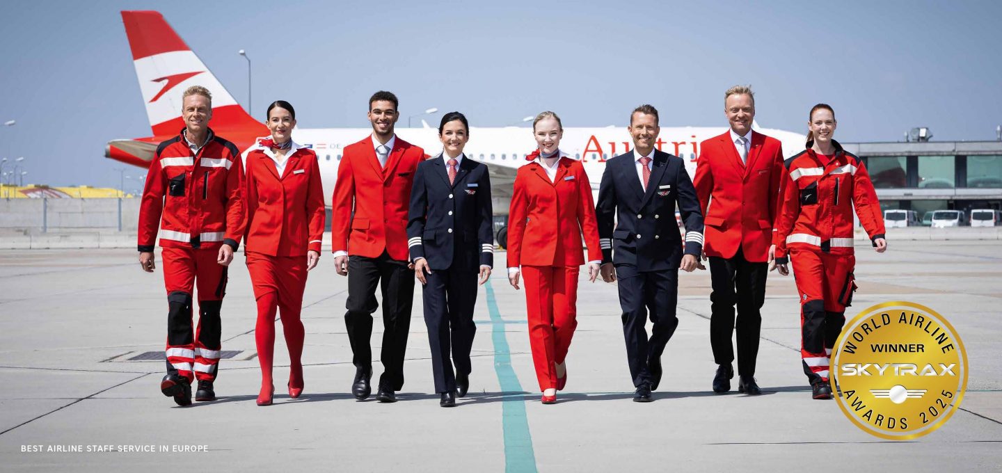 Flugbesatzung und Bodenpersonal auf dem Rollfeld mit einem Flugzeug von Austrian Airlines.