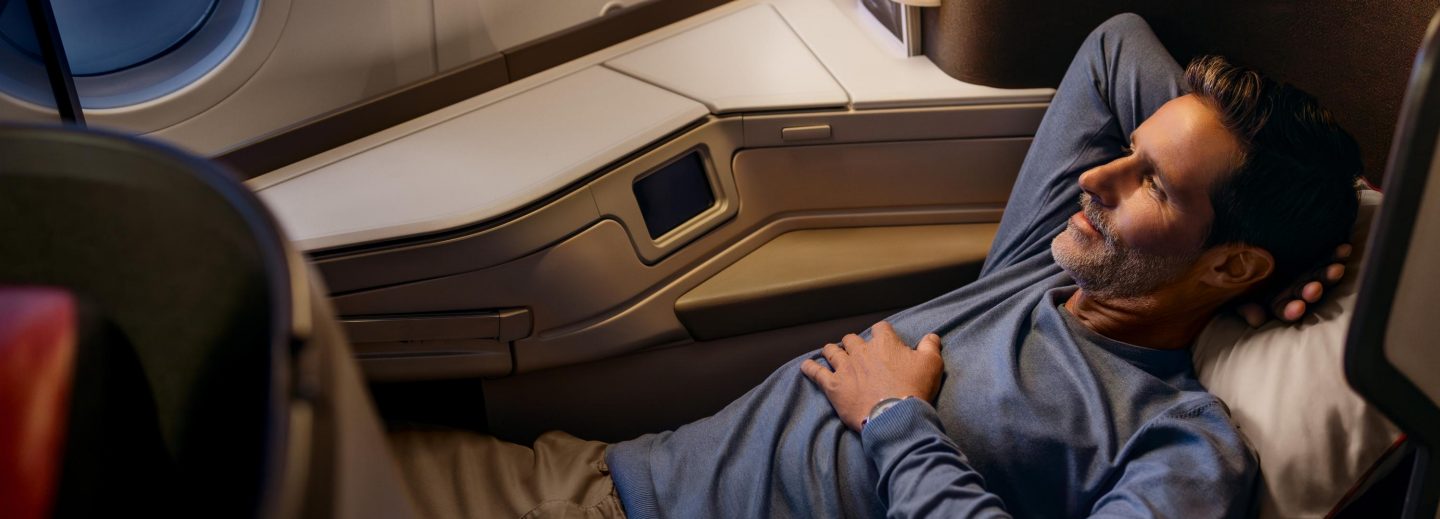 A man peacefully sleeping in his seat on an airplane.