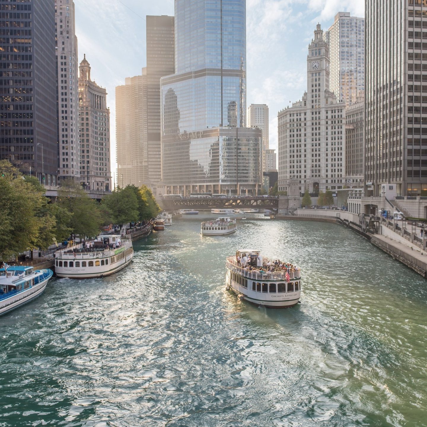 Blick auf den Chicago River im Stadtzentrum von Chicago, gesäumt von modernen Wolkenkratzern und historischen Hochhäusern unter klarem Himmel.