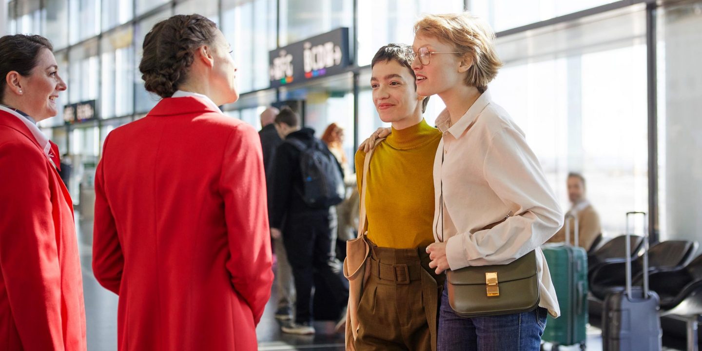 People talking in an airport, including airline staffs.