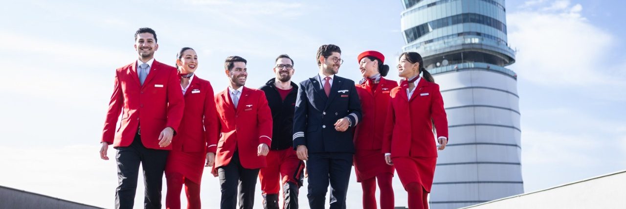 Austrian Airlines Flugbegleiter und Piloten gehen auf dem Rollfeld des Flughafens.