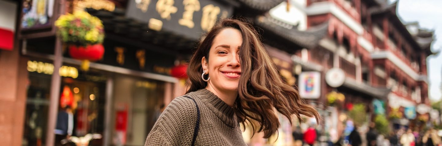Modern beautiful young female tourist exploring the streets of Shanghai on her vacation
