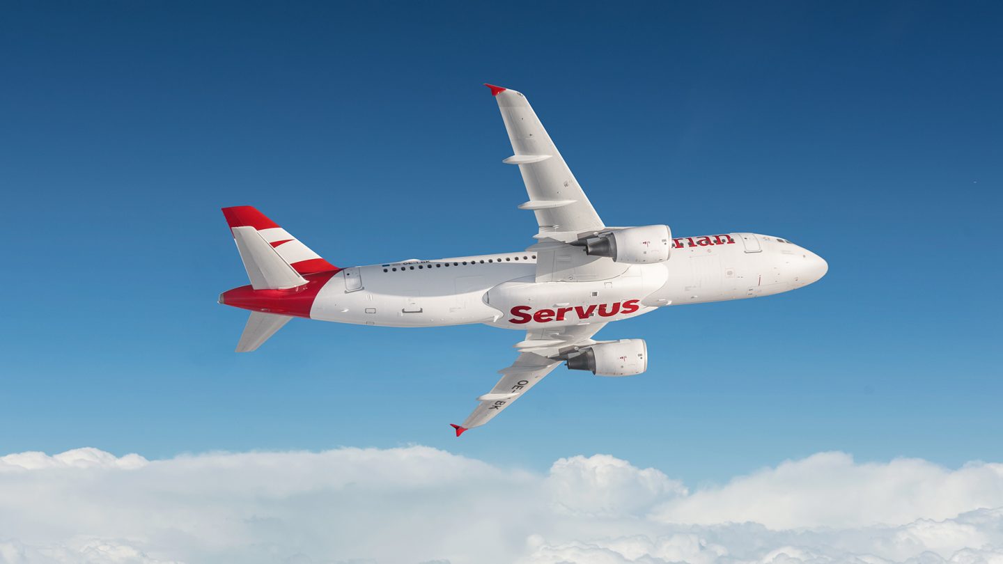 Austrian airplane soaring through a clear blue sky, symbolizing travel and adventure.