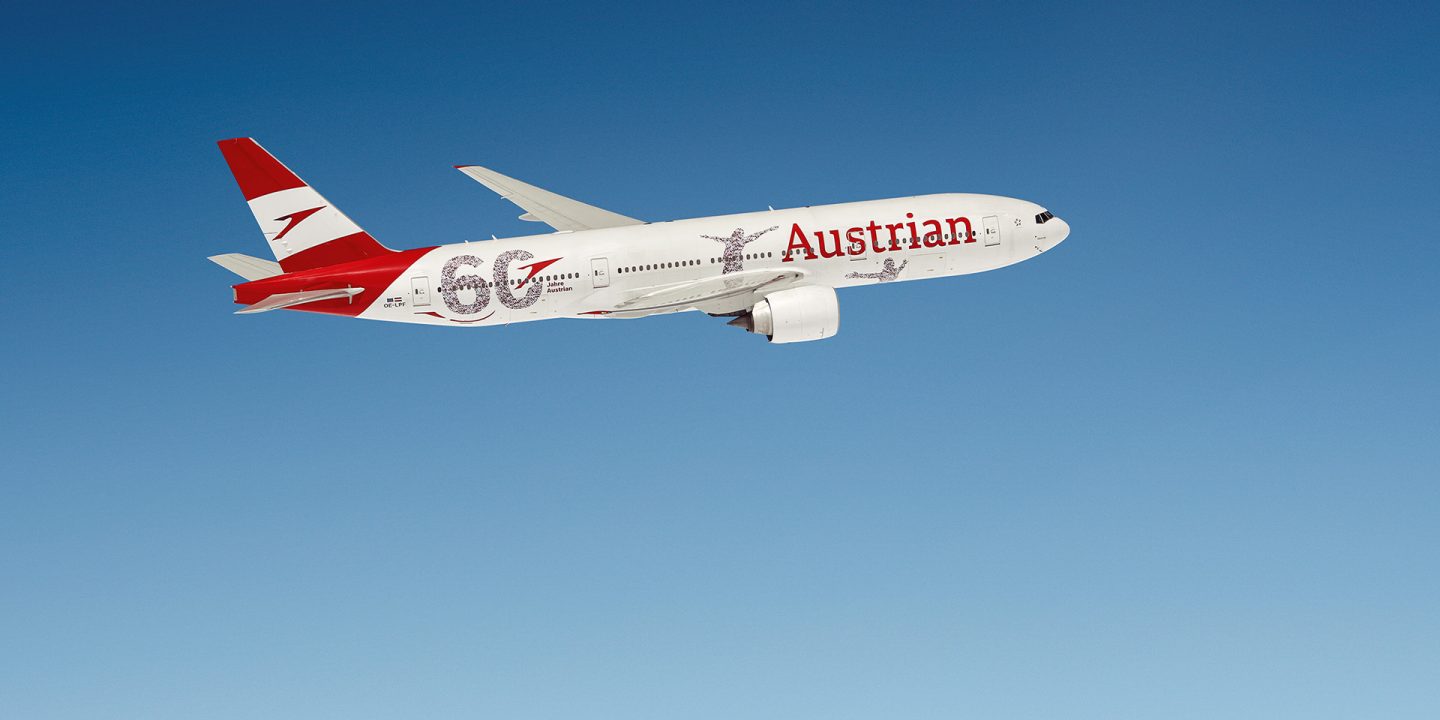 An airplane with "60 years Austrian" painting in the sky