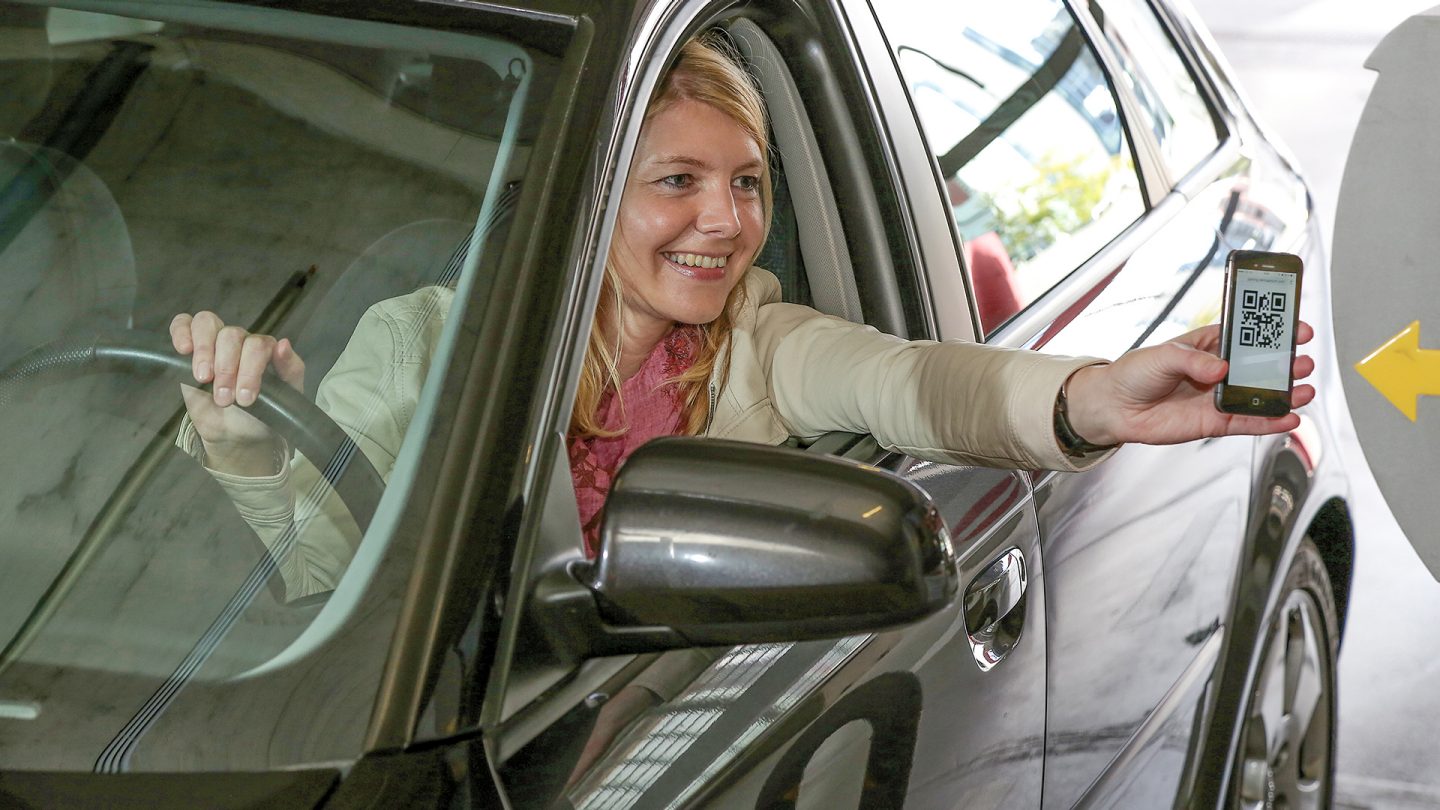 Woman scans QR code for parking on her smartphone