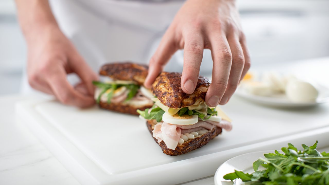 Hands preparing a lye roll sandwich