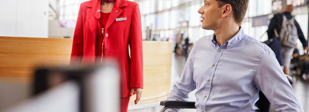 A man in a wheelchair gazes at a mannequin, emphasizing the importance of accessibility in travel.