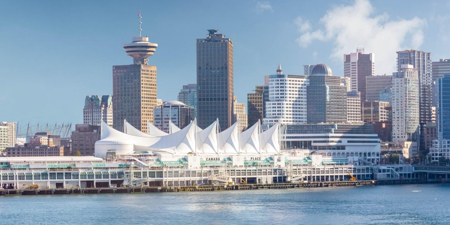 Vancouver, Canada skyline featuring modern buildings against a clear blue sky. Entry regulations for Canada apply.